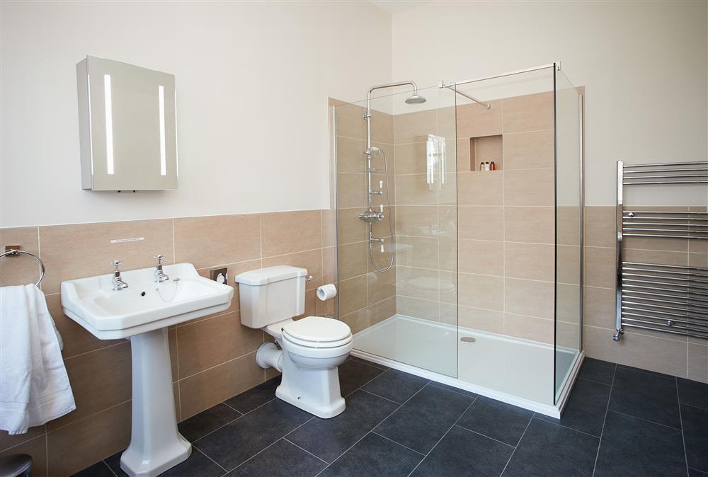 Bathroom with roll top bath and separate walk-in shower at The Sir Walter Scott Apartment, Netherby Hall, Longtown