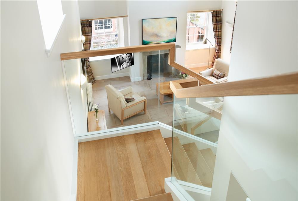 The contemporary style staircase leading out of the open plan living area up to the bedrooms  at The Sir Walter Scott Apartment, Netherby Hall, Longtown
