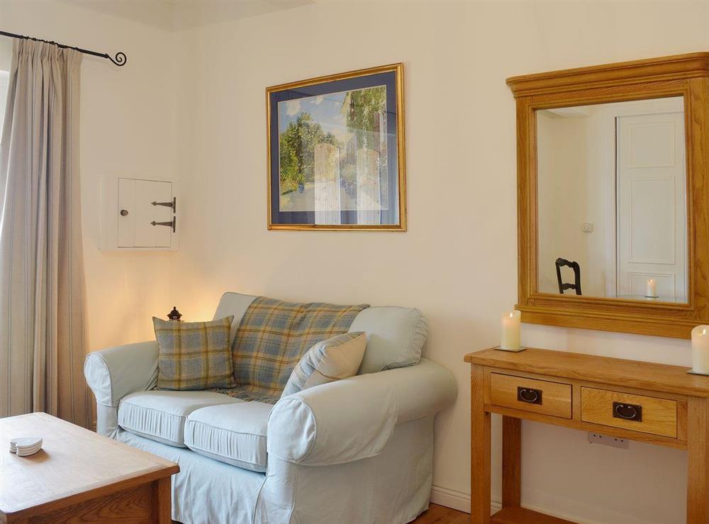 Cosy living area with comfortable sofa and fine furniture at The Stable in Port Of Menteith, Stirlingshire