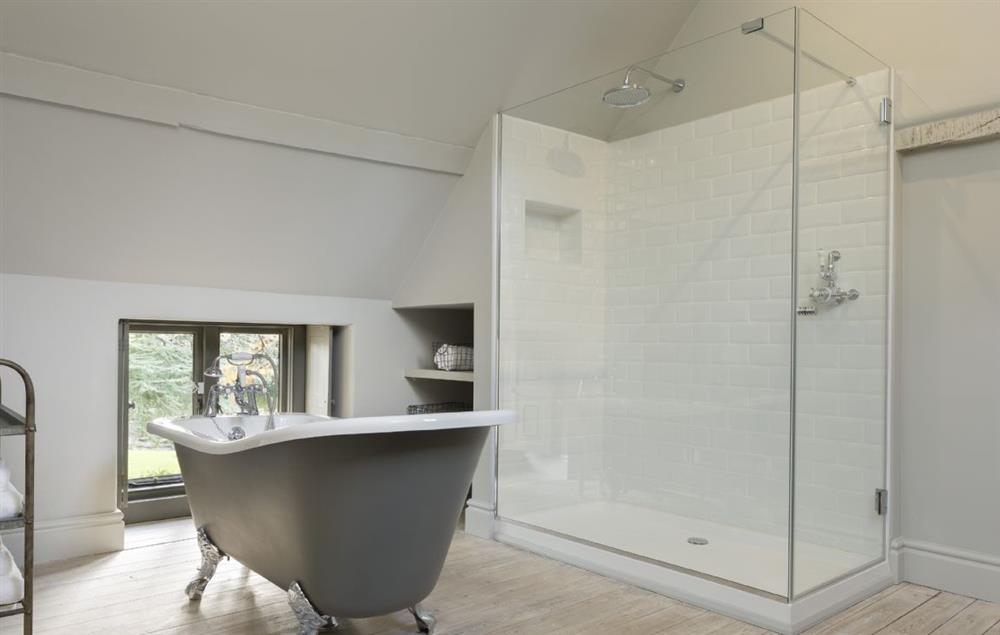 En-suite bathroom to bedroom two with a roll-top bath and walk-in shower at The Stables at The Lammas, Minchinhampton
