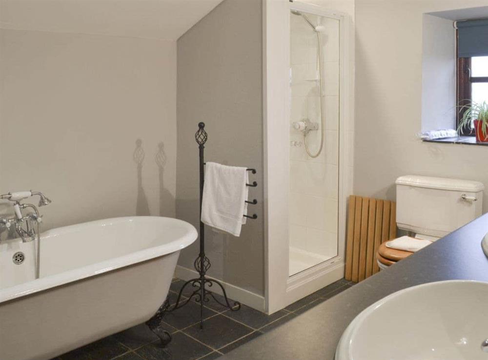 Roll-top bath and separate shower cubicle in bathroom at The Stables in near Criccieth, Gwynedd