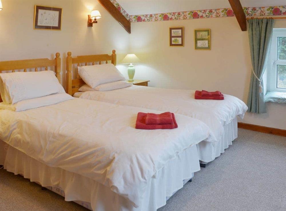 Twin bedroom with sloping and beamed ceiling at The Stables in Rezare, near Launceston, Cornwall