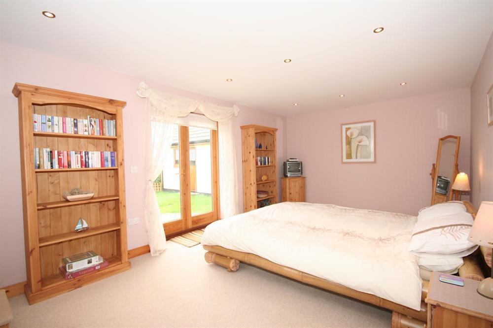 Master bedroom with King-size bamboo bed at The Station in Malborough, Nr Kingsbridge