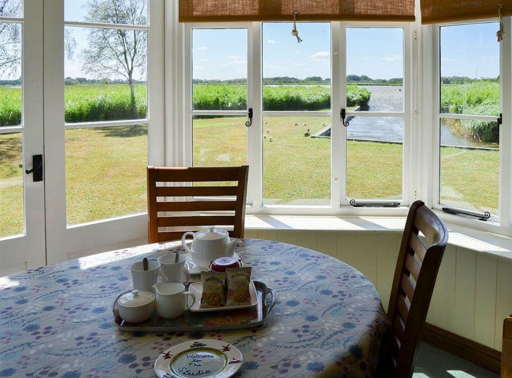 Dining area overlooking the lawned garden at The Studio in Hickling, Norfolk., Great Britain