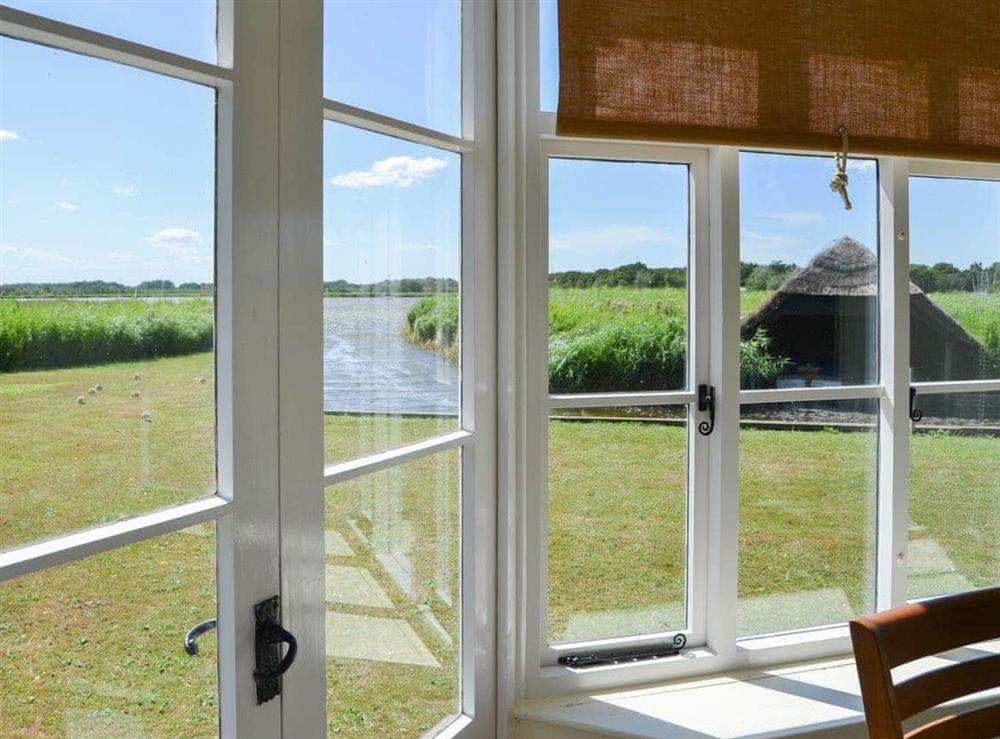 Sunny conservatory with double doors to the waterside garden at The Studio in Hickling, Norfolk., Great Britain