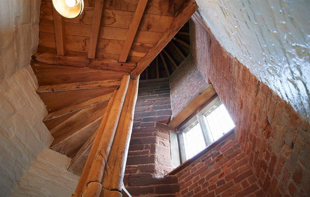 A wooden spiral staircase takes guests to the first floor bedroom at The Summer House, Eyton on Severn
