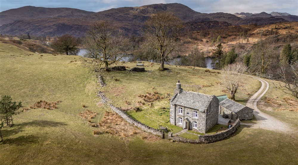 An aerial view of Rose Castle Cottage with the waters of Tarn How in the background, Cumbria at The Summer House in Nr Hawkshead, Cumbria