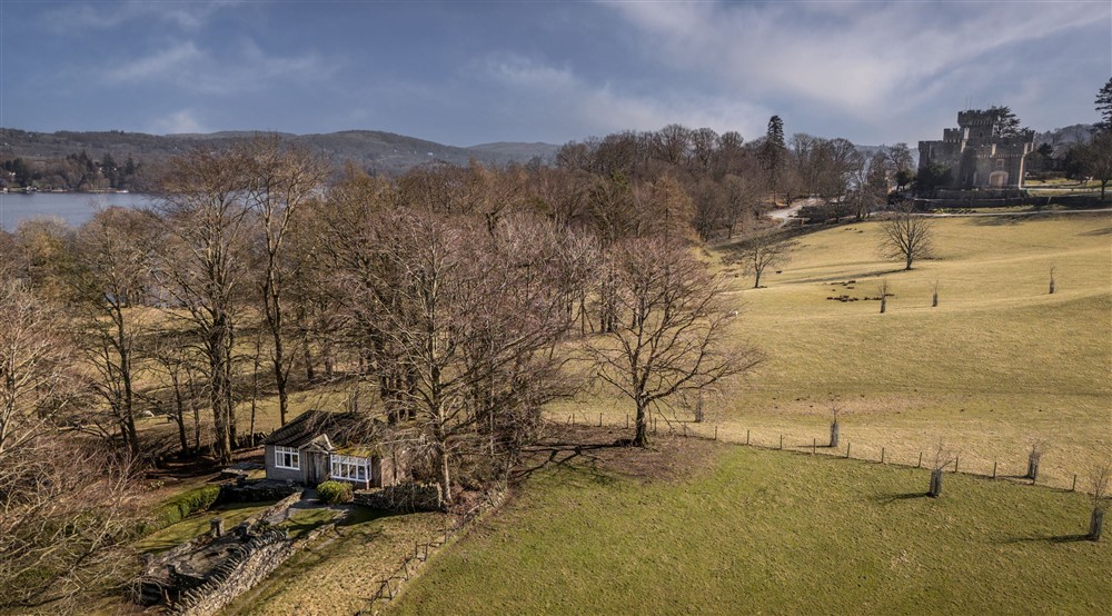 An aerial view of The Summer House, with Wray Castle and Lake Windermere in the background, Cumbria at The Summer House in Nr Hawkshead, Cumbria