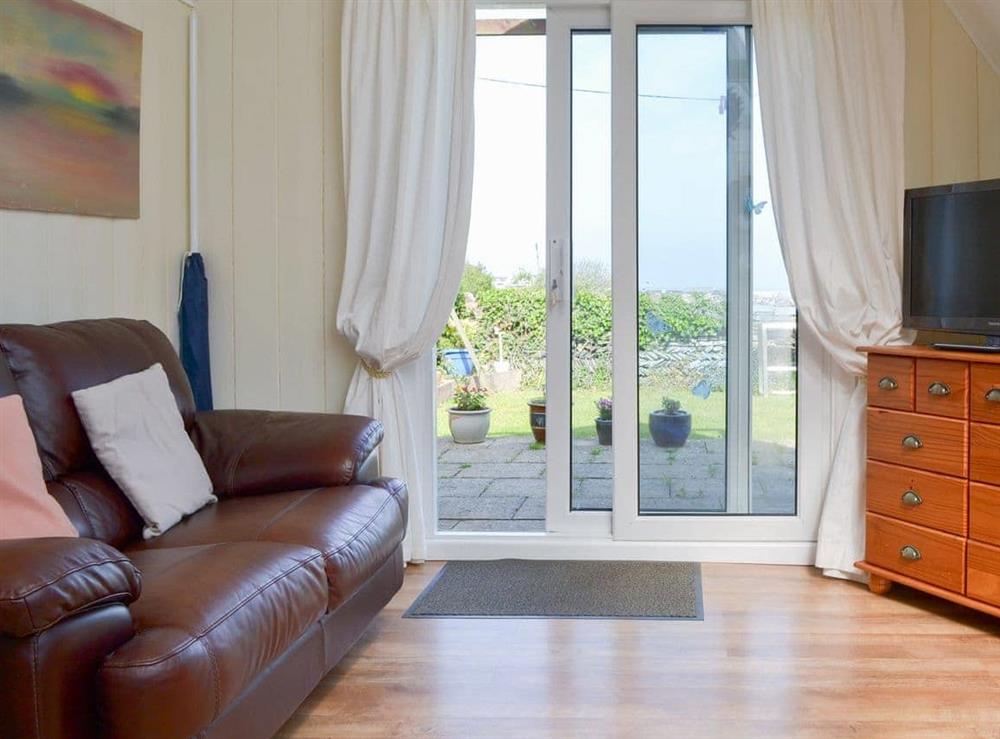 Welcoming living room with patio doors at The Summer House in Tintagel, Cornwall, Great Britain