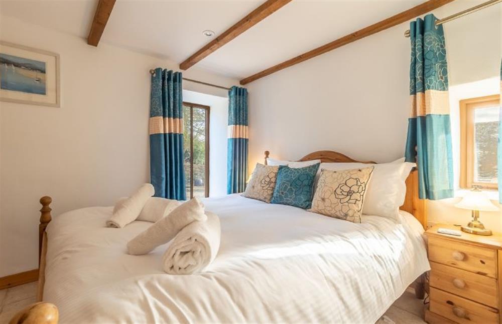 Bedroom one with a king-size bed and en-suite at The Threshing Barn, Cusgarne, Truro 