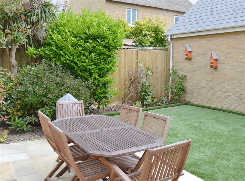 Paved patio with outdoor furniture at The Tides in Bridport, Dorset