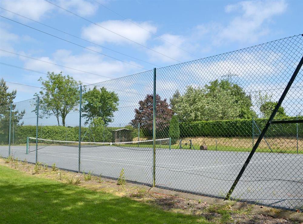Full hard standing tennis court at The Tithe Barn in Huxham, near Exeter, Devon