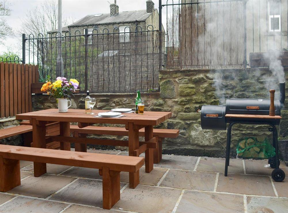 Enclosed courtyard with outdoor furniture and BBQ at The Town House in Haworth, West Yorkshire