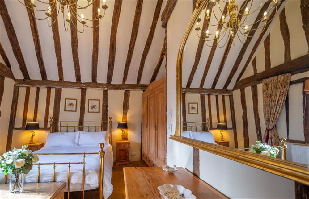 Bedroom one with an impressive 21 arm brass chandelier at The Tryst, Lavenham