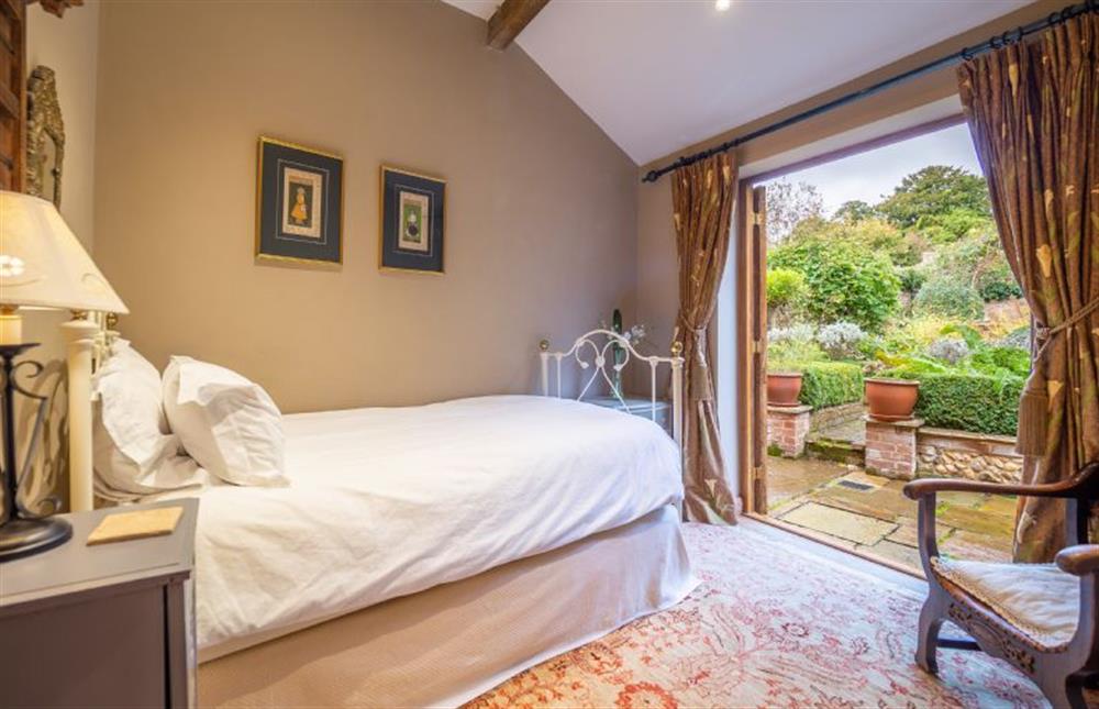 Ground floor bedroom three with 3’ single bed and french doors to the garden at The Tryst, Lavenham
