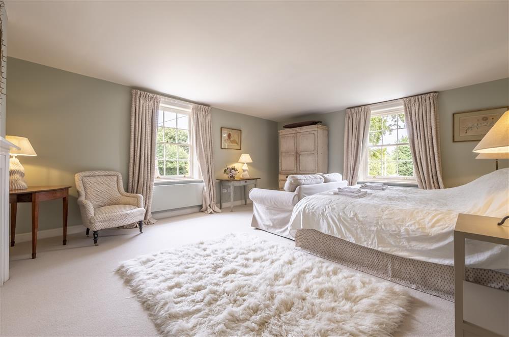 Elegant bedroom five with a 6’ super-king size bed at The Vicarage and Cottage, Great Limber
