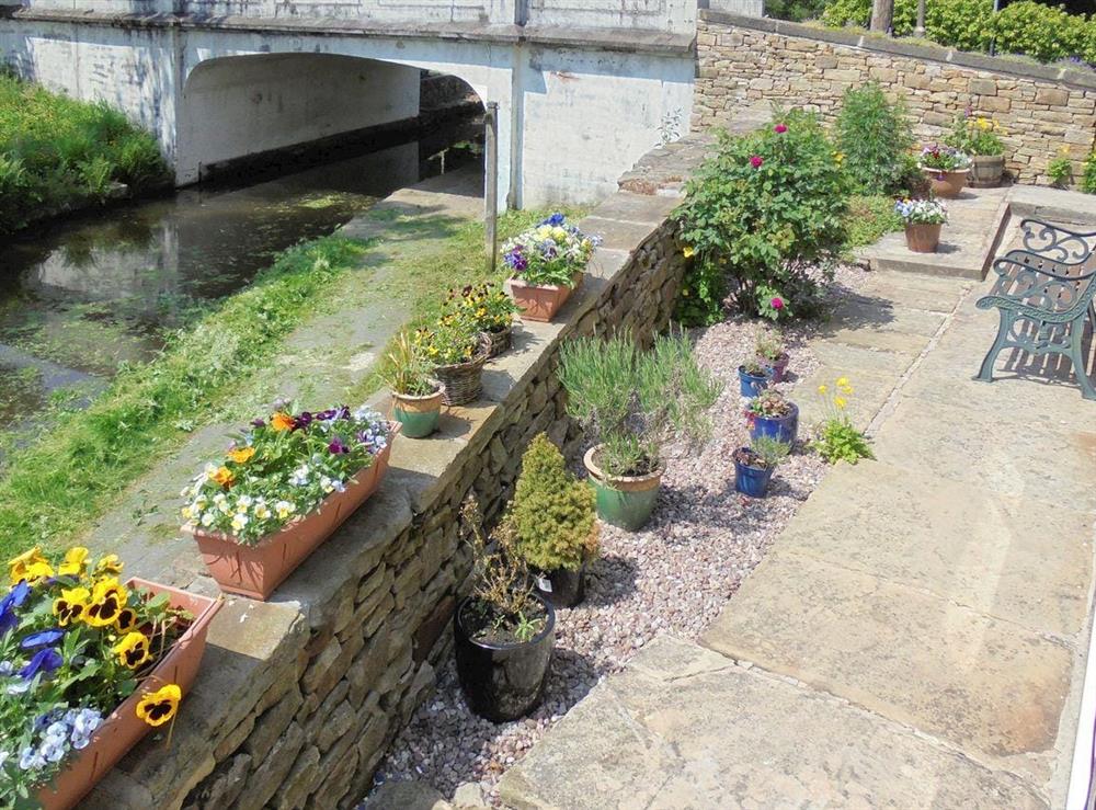Courtyard garden overlooking canal at The White Cottage in Furness Vale, near Whaley Bridge, Derbyshire