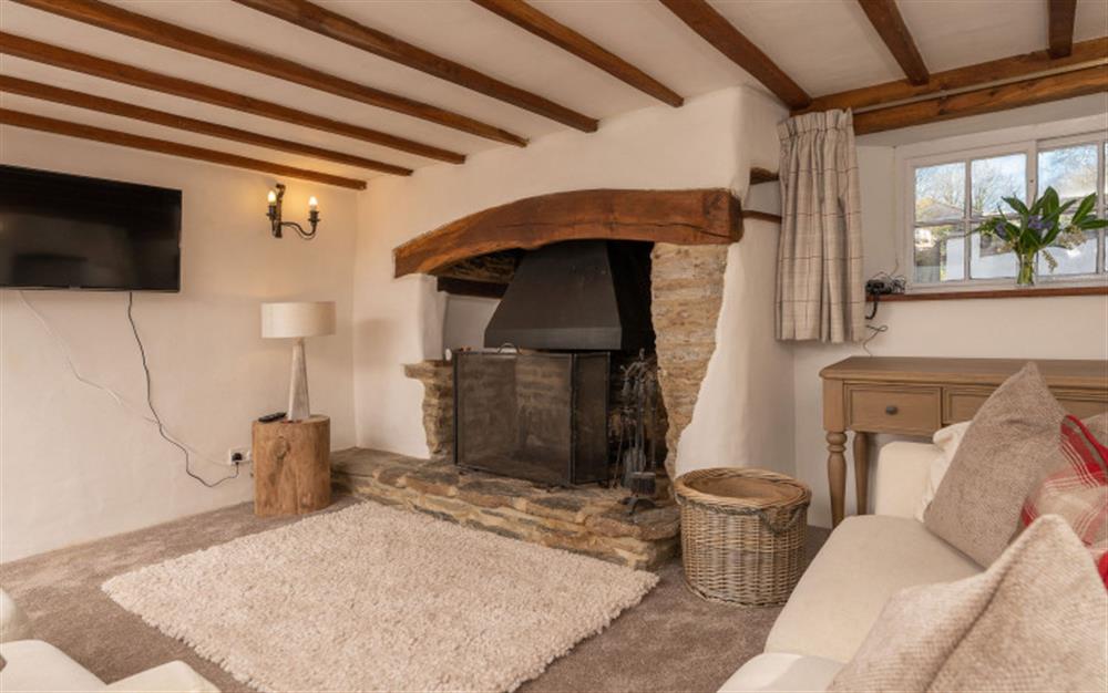 The lounge with open fire  at The White Cottage in South Milton