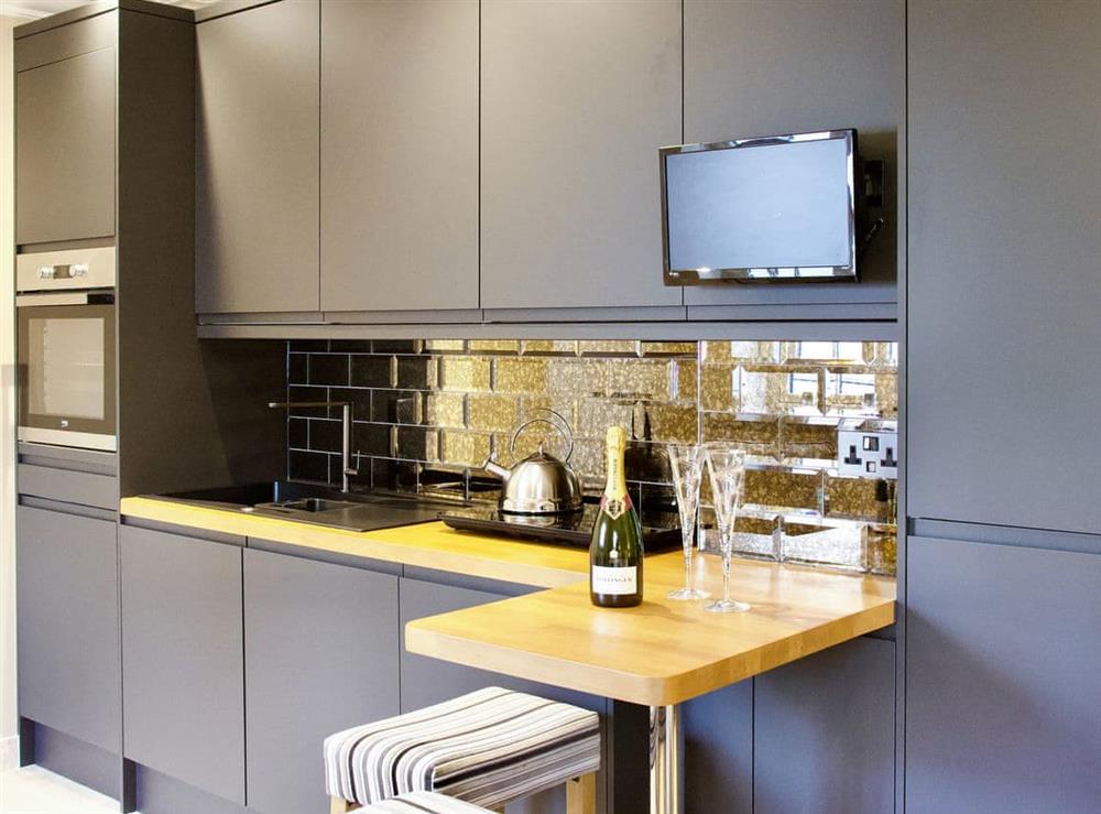 Compact kitchen with breakfast bar at The White House Studio in Worthing,  Sussex, England