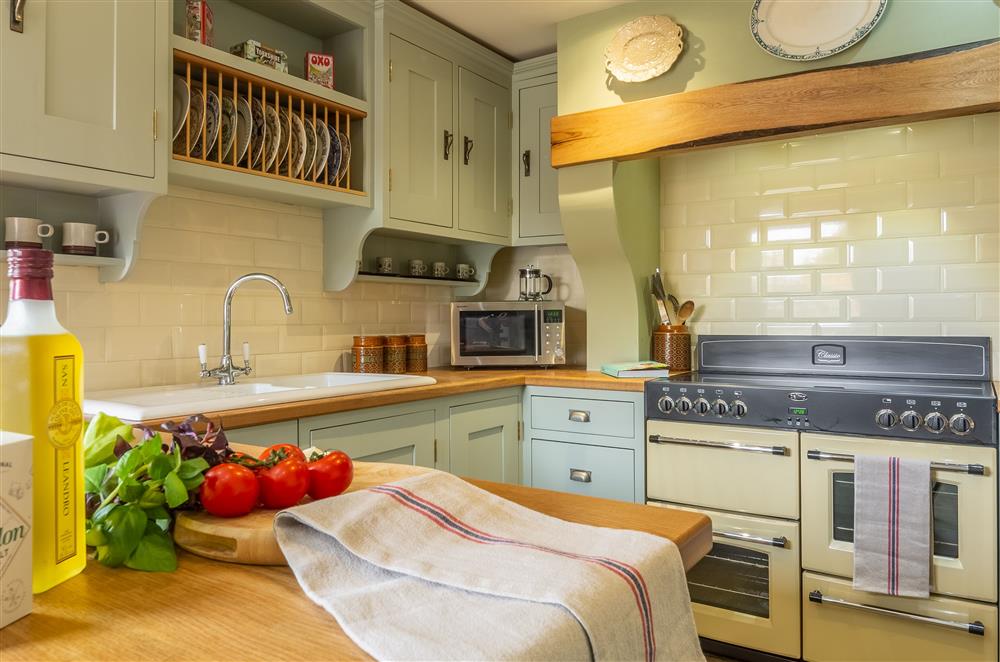 Well-equipped kitchen with french doors leading to the enclosed courtyard garden at Theaked Stones, Leyburn