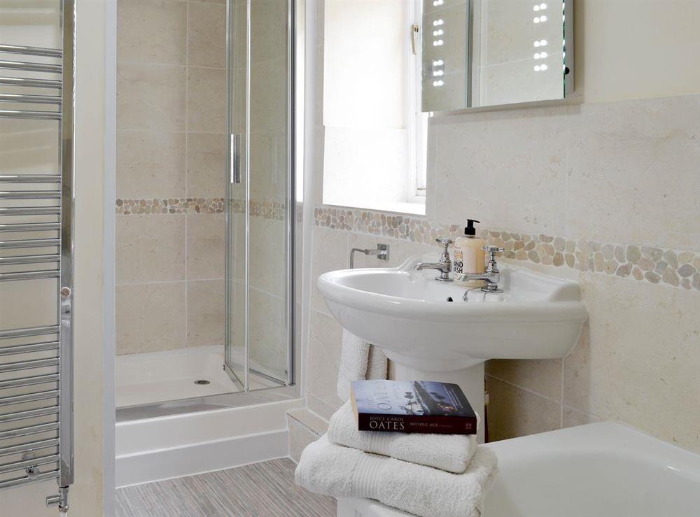 En-suite bath and shower room with heated towel rail at Thimble Cottage in Hartland, North Devon., Great Britain