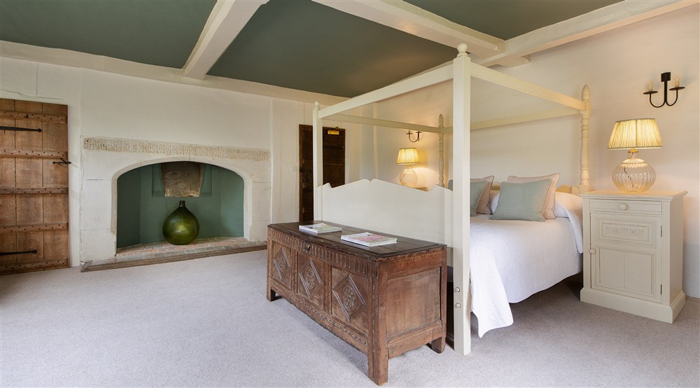 Bedroom 2 Strutt, with a super king-size, four-poster bed and en-suite shower room, on the first floor of Thorington Hall, Suffolk at Thorington Hall in Stoke By Nayland, Suffolk
