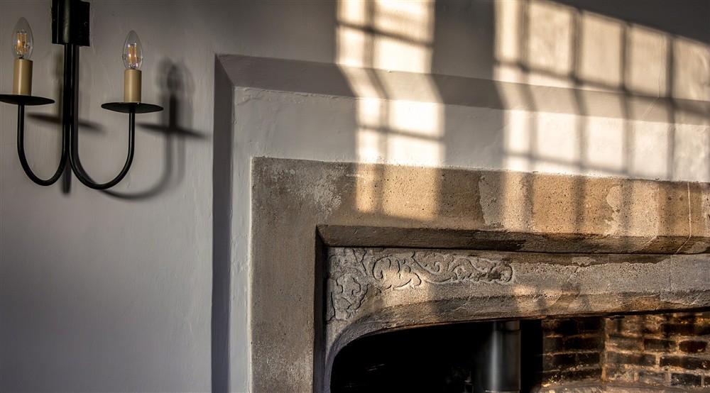 Carved details in the stone of the fireplace in the dining room at Thorington Hall in Stoke By Nayland, Suffolk