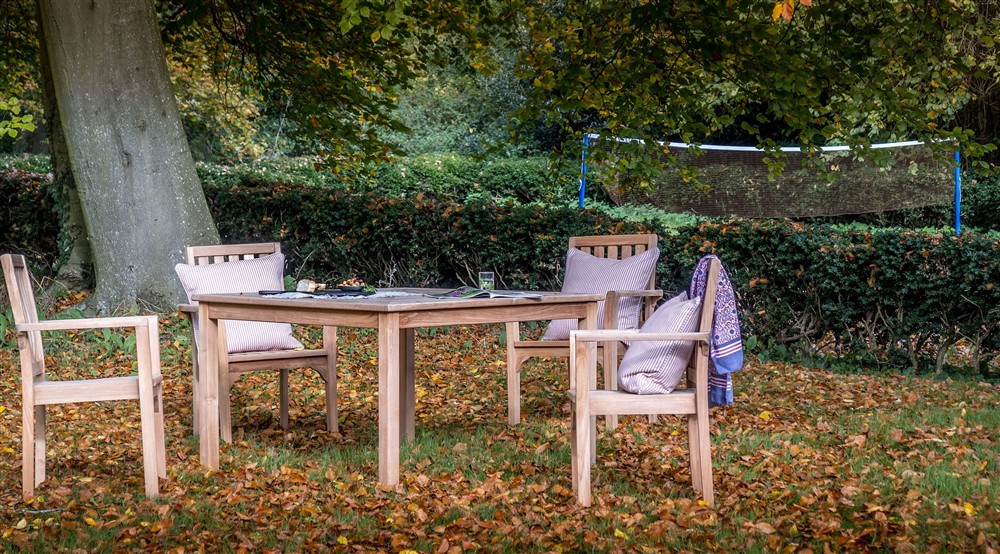 Outdoor dining furniture in the garden of Thorington Hall, with the badminton area in the background, Suffolk at Thorington Hall in Stoke By Nayland, Suffolk