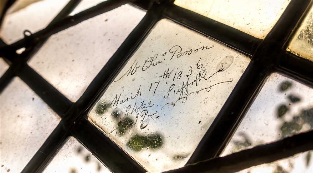 Signatures of previous owners, etched into one of the windows at Thorington Hall in Stoke By Nayland, Suffolk
