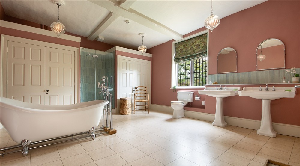 The first-floor bathroom, with roll-top bath and walk-in shower, at Thorington Hall in Stoke By Nayland, Suffolk