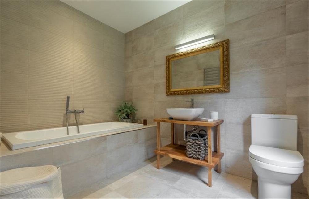 Ground floor: En-suite bath with hand-held shower in bedroom three at Thursford Castle, Great Snoring