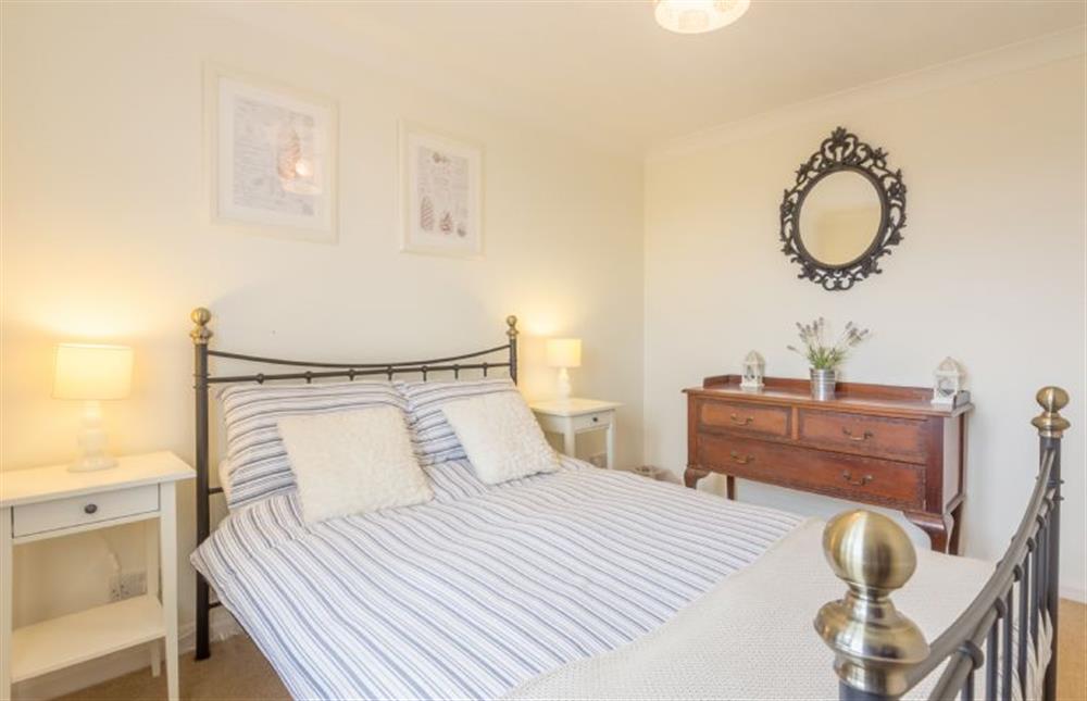 First floor: Bedroom one has a comfortable wrought iron bed at Tide Cottage, Holme-next-the-Sea near Hunstanton