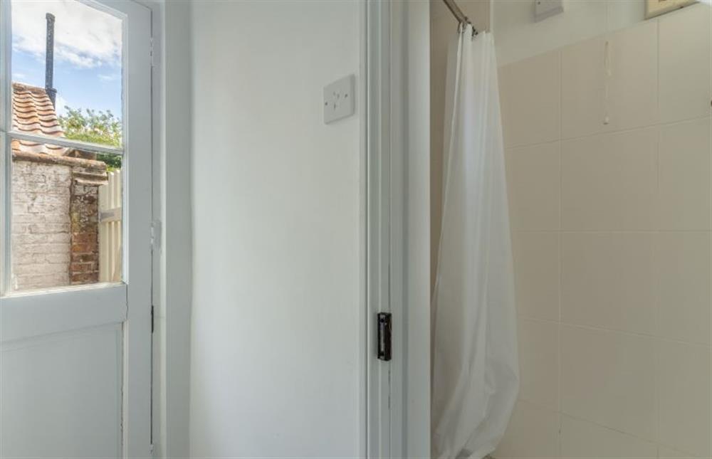 Ground floor: Door out to garden with view to downstairs shower room at Tide Cottage, Overstrand near Cromer