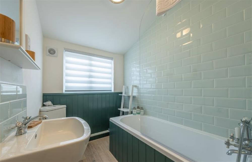 First floor: Bathroom with a bath and shower over, wash basin and WC at Tide Cottage, West Runton near Cromer