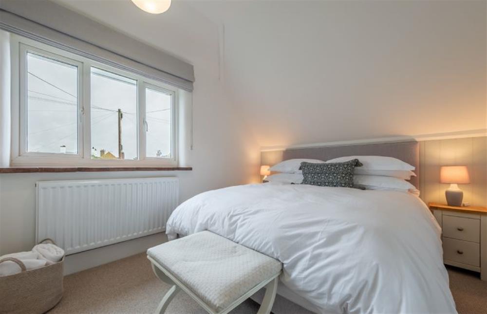 First floor: Bedroom two with a super-king size bed and a glimpse of the sea at Tide Cottage, West Runton near Cromer