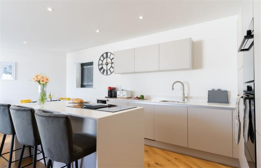 A kitchen island with a breakfast bar that seats three guests at Tidelines, Newquay