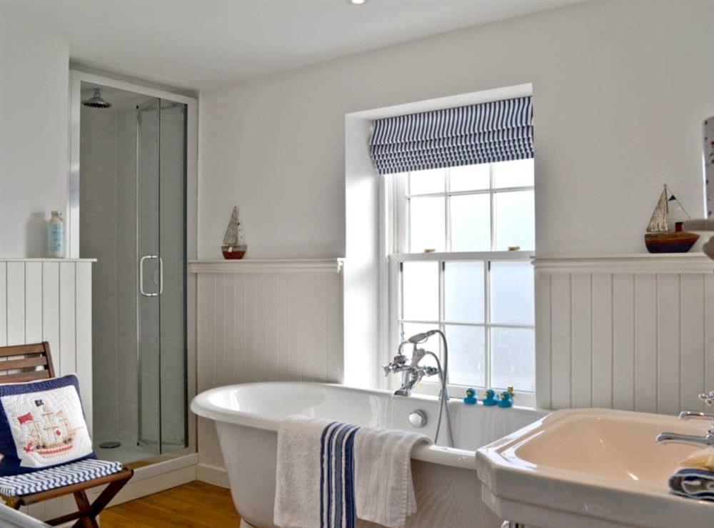 Light and airy bathroom with roll-top bath and separate shower cubicle at Tides in Cromarty, Ross-Shire