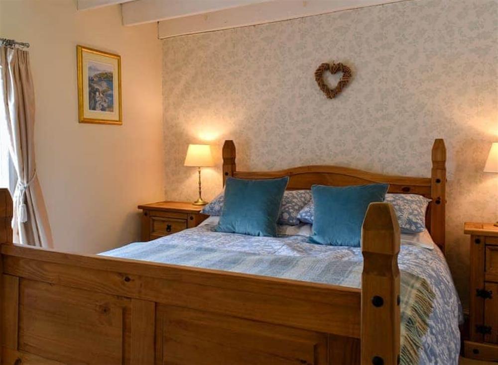 Bedroom with kingsize bed and beams at Tillys Cottage in Goathland, Great Britain