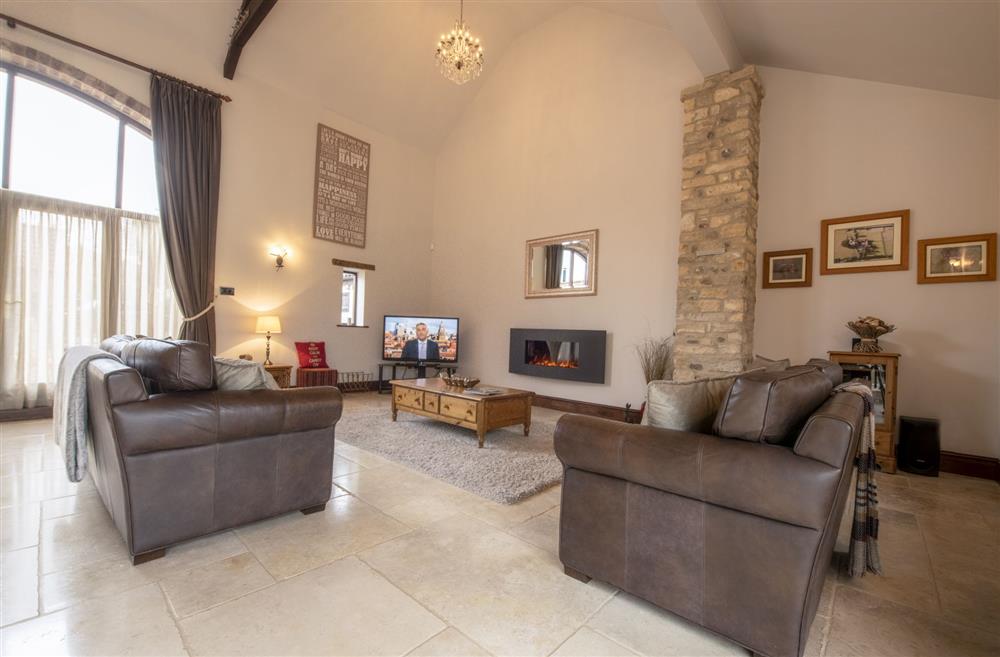 The open-plan sitting area with electric living flame fire at Tockwith Lodge Barn, York