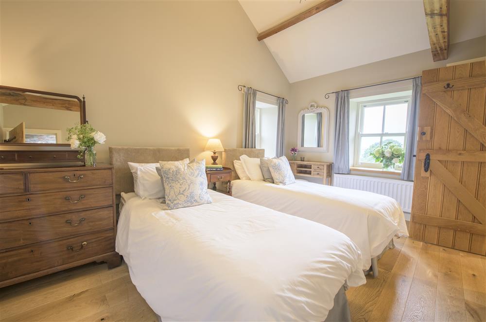 Bedroom one with twin 3’ zip and link single beds and en-suite shower room at Todd Hills Hall Farmhouse and Vale Croft, Melmerby