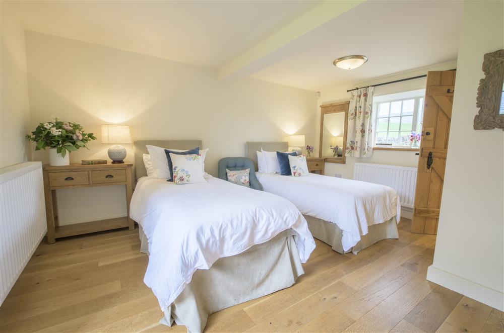 Bedroom six on the ground floor with twin 3’ single zip and link beds and en-suite shower room at Todd Hills Hall Farmhouse and Vale Croft, Melmerby