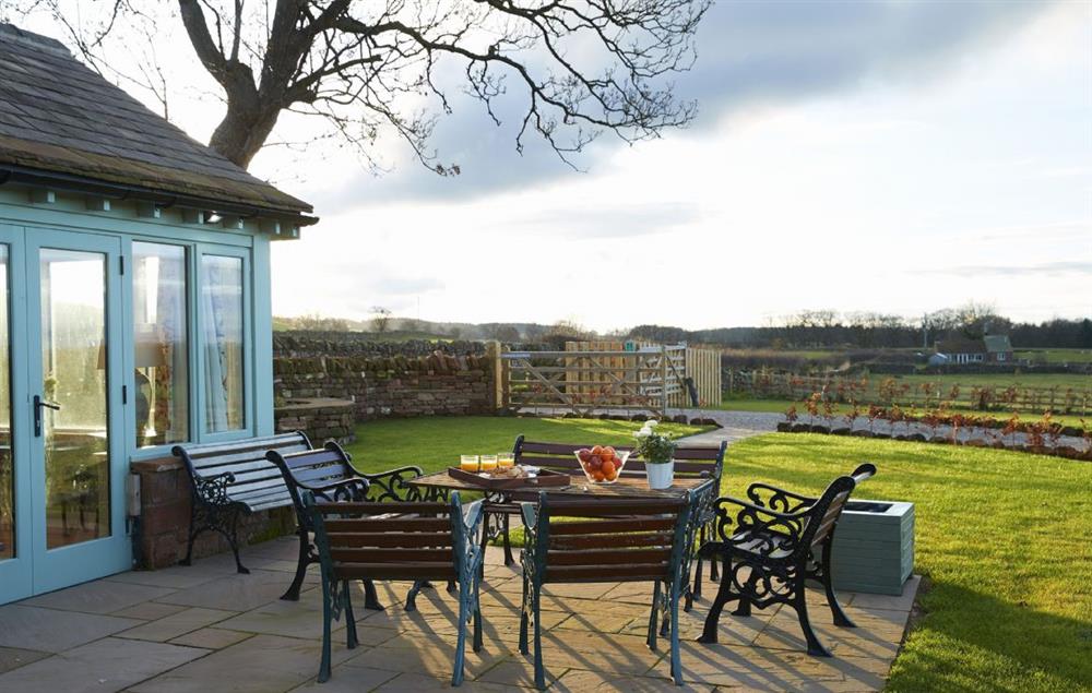 Extensive sandstone terrace with garden furniture  at Todd Hills Hall Farmhouse, Melmerby