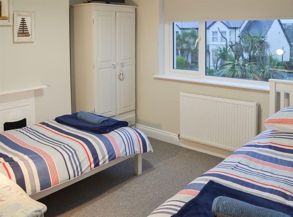 Pretty bedroom with twin single beds at Tolcarne Retreat in Newquay, Cornwall