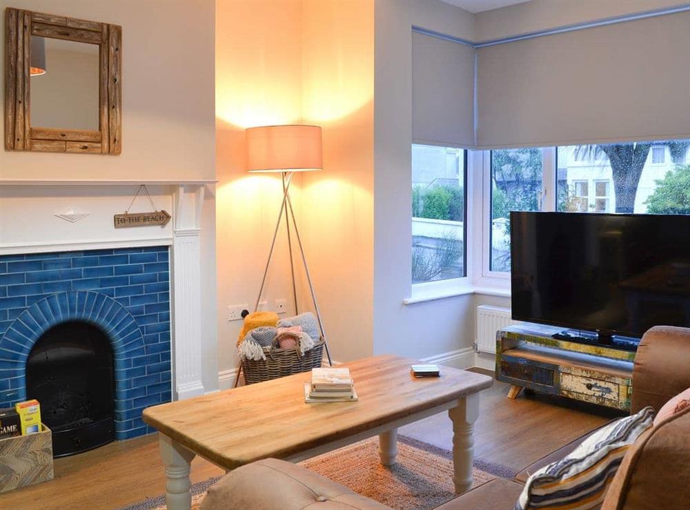 Wonderful bay-windowed living room with beautiful tiled feature fireplace at Tolcarne Retreat in Newquay, Cornwall