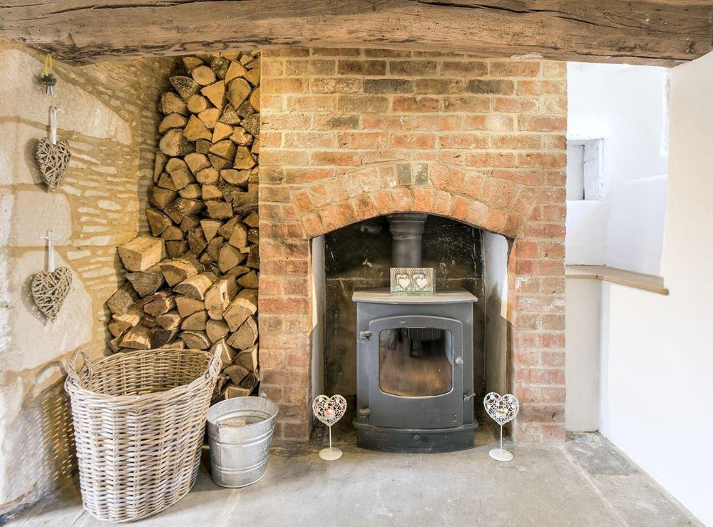 Wood-burning stove set in an inglenook fireplace at Tom Cottage in Wing, near Oakham, Leicestershire