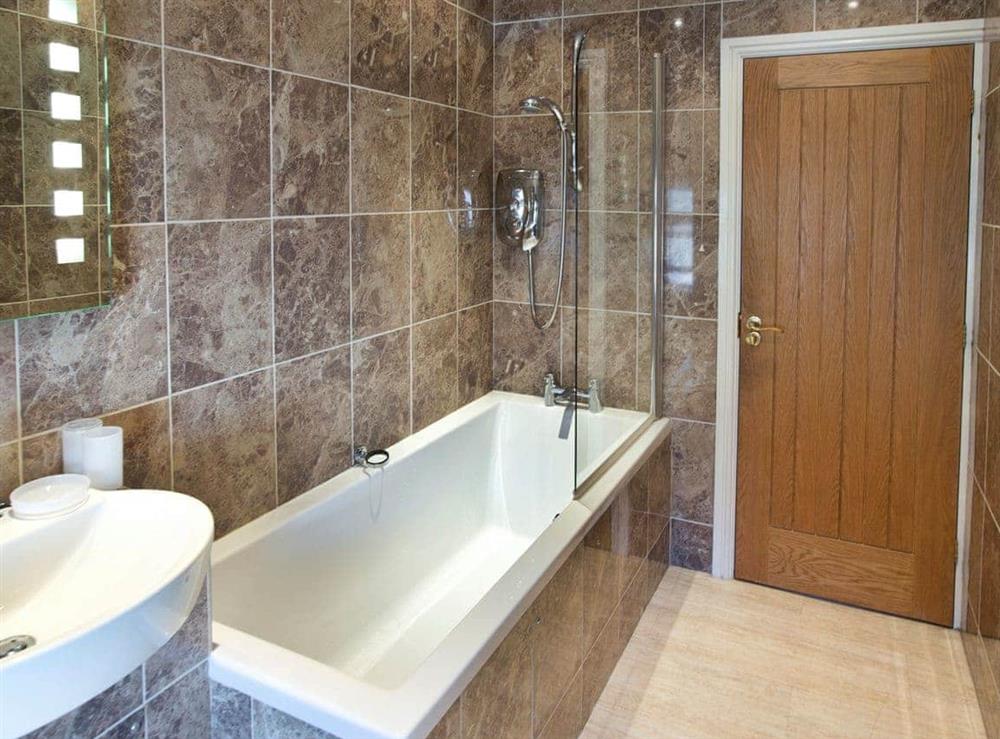 First floor bathroom with shower over bath at Tommys Cottage in Keswick, Cumbria