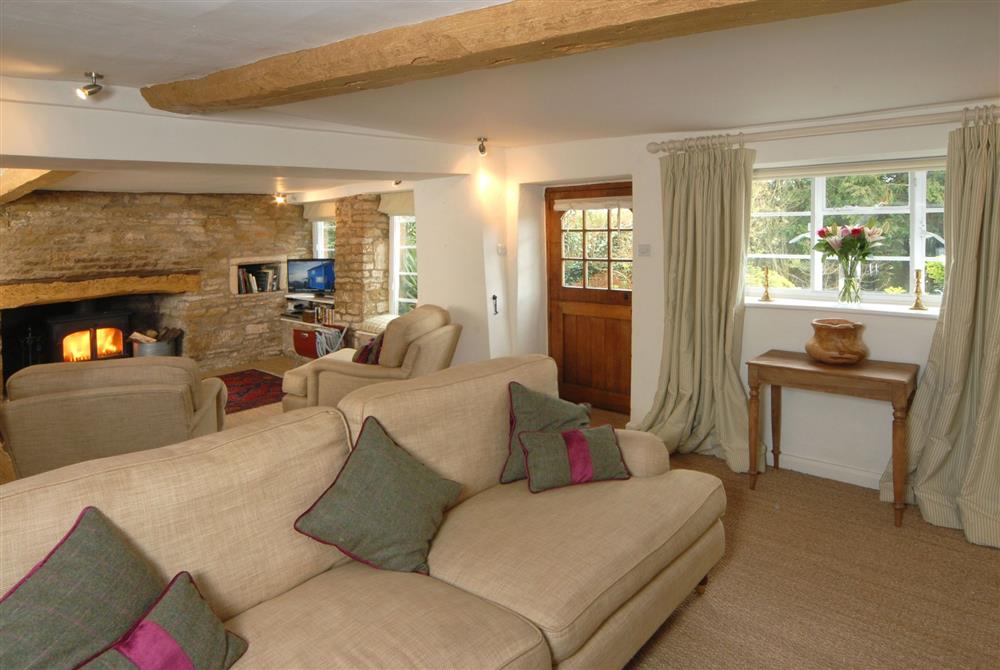 Cosy sitting room with inglenook fireplace, bread oven and wood burning stove at Top Cottage, Oddington, Upper Oddington