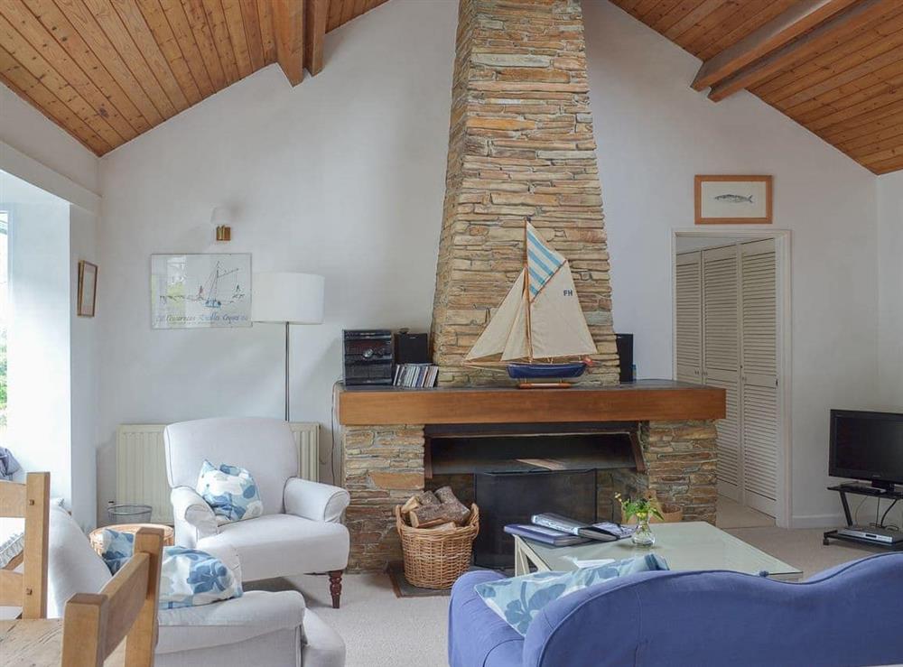 Delightful open plan living space with feature fireplace and wooden ceiling at Topsail in Noss Mayo, South Devon., Great Britain