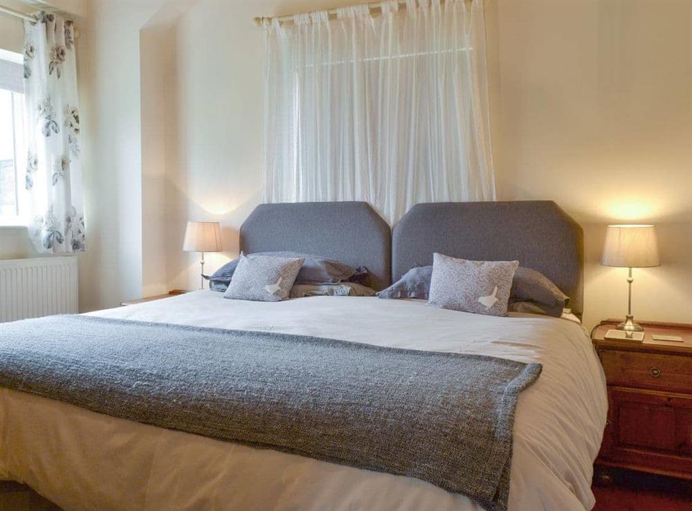 Comfortable double bedroom with en-suite bathroom at The Cowshed, 