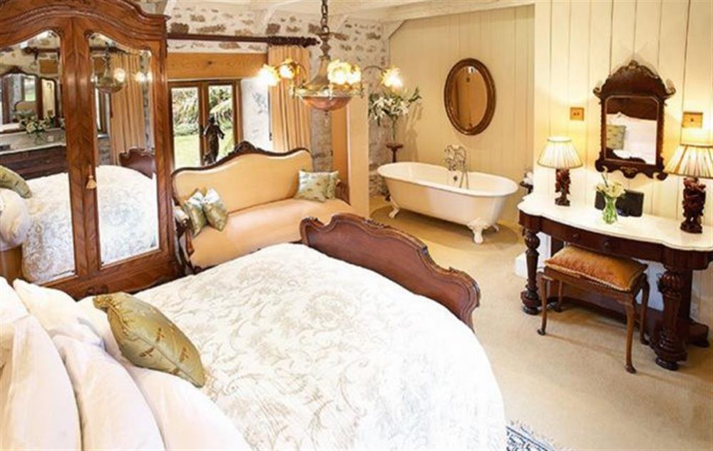 Master bedroom with 4’6 bed roll top bath and en-suite WC at Tregadjack Barn, Tregathenan
